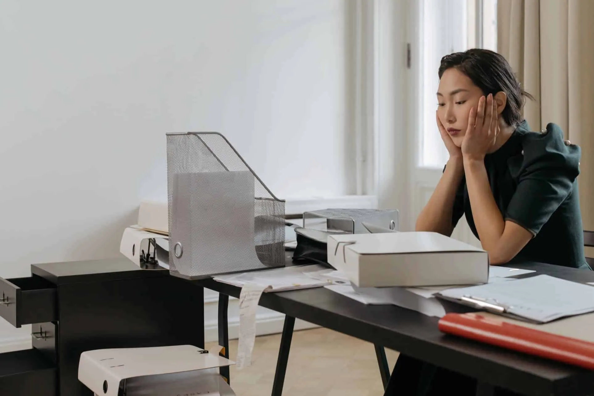 Woman sitting at her desk and using laptop in office